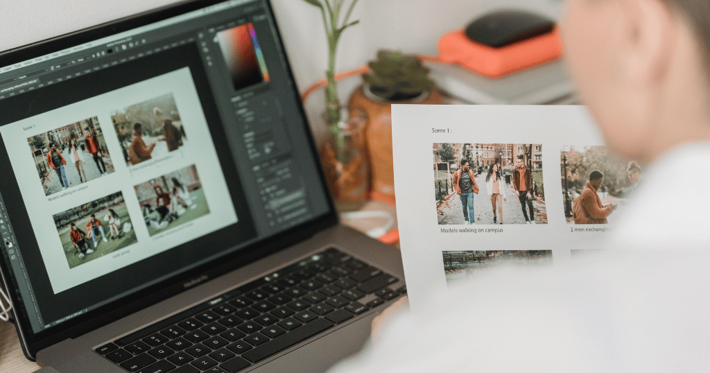 Uma pessoa mexendo no computador escolhendo fotografias com um papel na mão