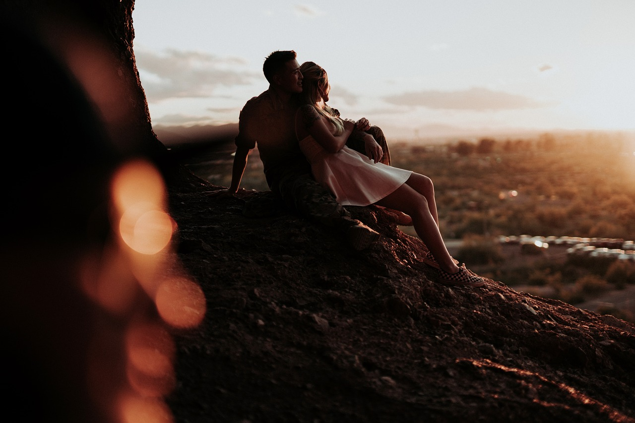 casal se abraçando sentados em uma pedra sorrindo